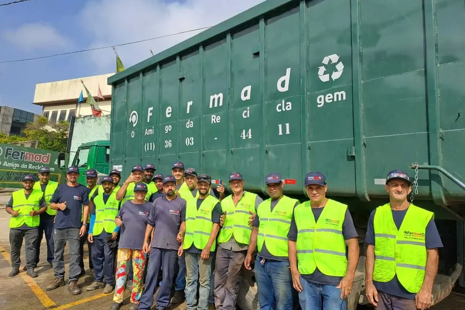 Equipe da Fermad reunida em frente à caçamba da empresa